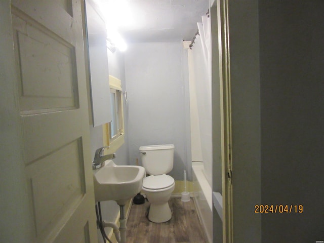 bathroom with a sink, shower / bath combo, wood finished floors, and toilet