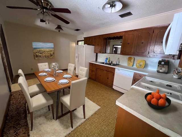 kitchen with light countertops, white appliances, light floors, and a sink