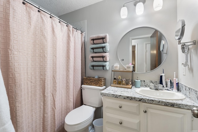 bathroom featuring a textured ceiling, toilet, and vanity