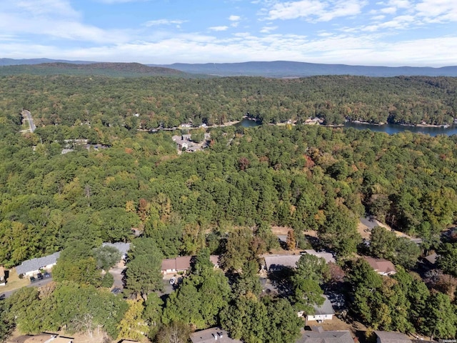 aerial view featuring a wooded view and a water and mountain view