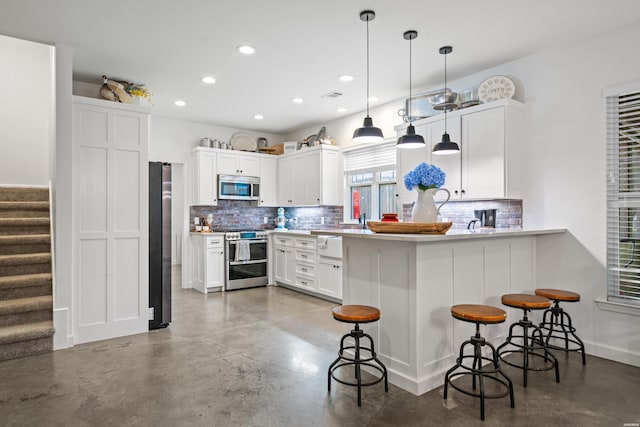 109 Spencer Chase Ct, Hot Springs, AR 71901 - kitchen featuring stainless steel appliances, concrete floors, decorative backsplash, recessed lighting, and a breakfast bar area