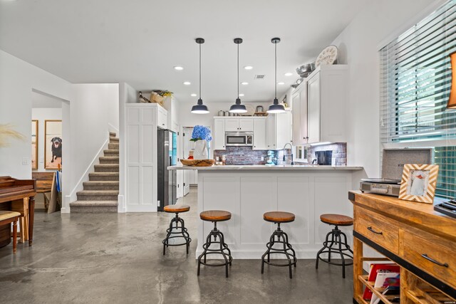 109 Spencer Chase Ct, Hot Springs, AR 71901 - kitchen featuring stainless steel appliances, backsplash, a peninsula, white cabinetry, and concrete flooring
