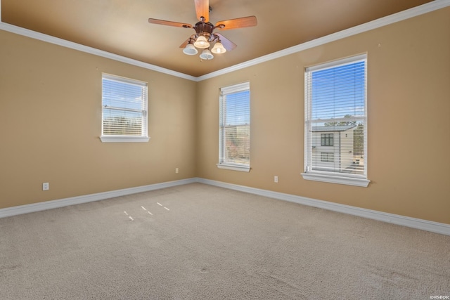 empty room with light colored carpet, baseboards, crown molding, and a ceiling fan