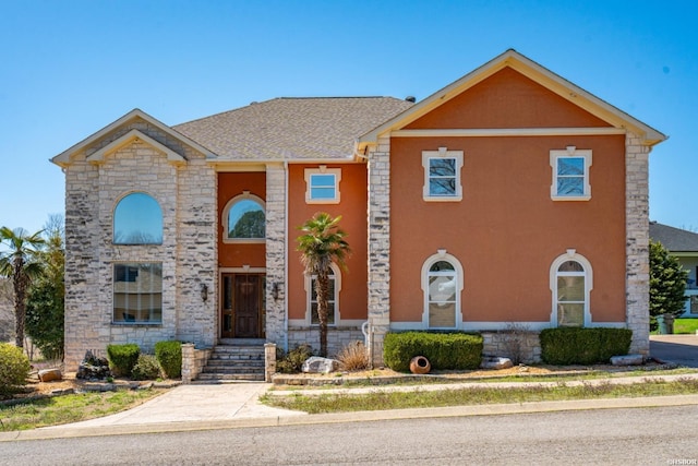 view of front of home with a shingled roof and stucco siding