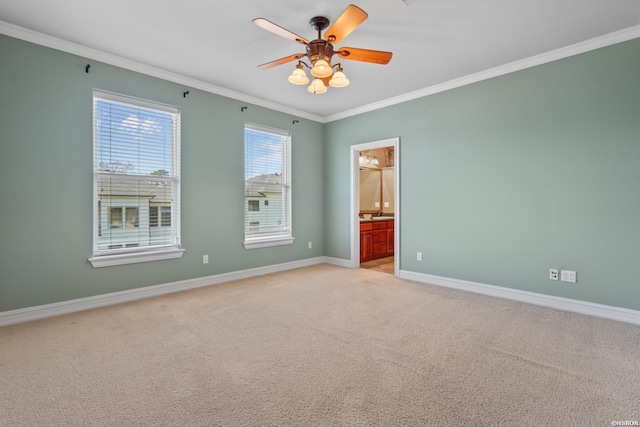 empty room with ceiling fan, crown molding, baseboards, and light carpet