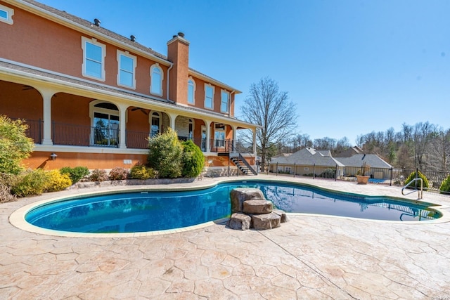 view of swimming pool featuring a patio, stairway, fence, and a fenced in pool