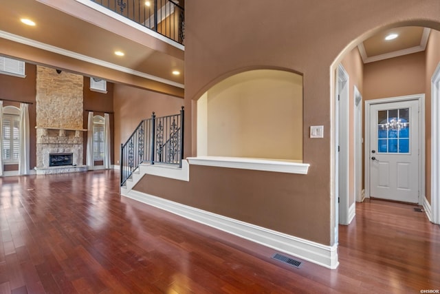 interior space with wood finished floors, visible vents, a towering ceiling, and baseboards