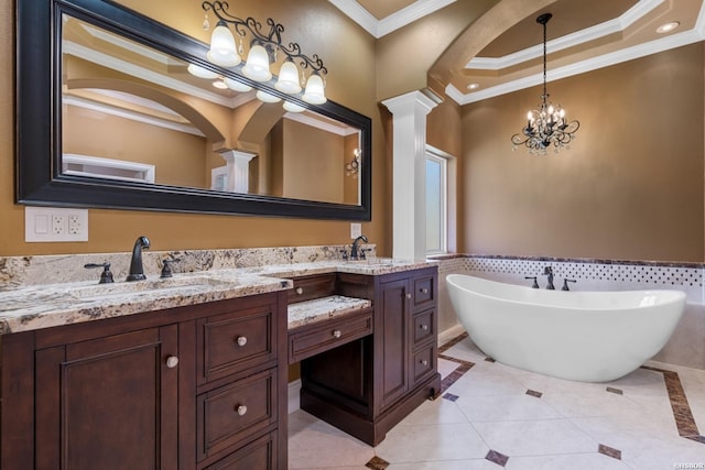 full bath with a freestanding bath, double vanity, ornamental molding, ornate columns, and a sink