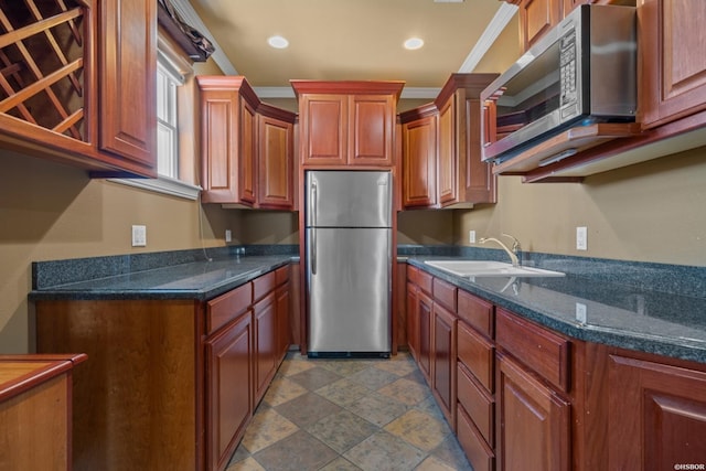 kitchen with brown cabinets, ornamental molding, a sink, recessed lighting, and stainless steel appliances