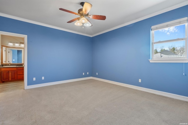 spare room featuring light colored carpet, a ceiling fan, baseboards, and ornamental molding