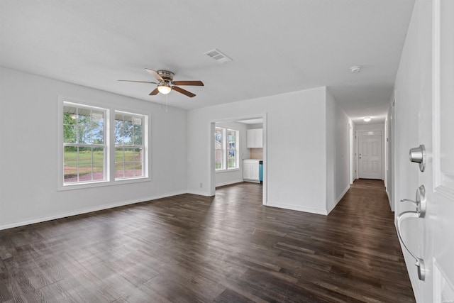 empty room with ceiling fan, baseboards, visible vents, and dark wood finished floors