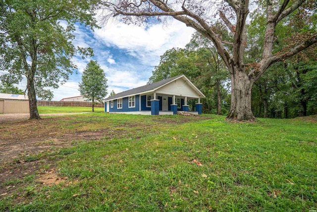 view of front of home with fence, a porch, and a front yard