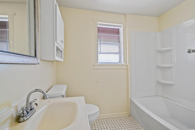bathroom featuring shower / washtub combination, toilet, a sink, tile patterned flooring, and baseboards