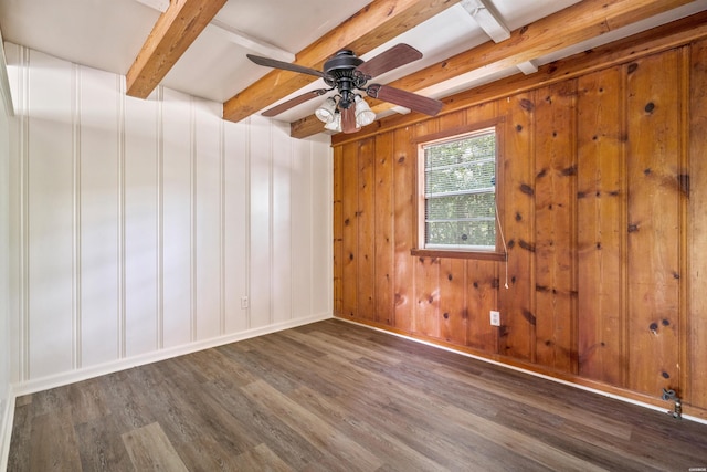 unfurnished room with a ceiling fan, baseboards, dark wood-type flooring, and beamed ceiling