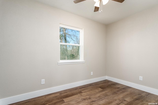 spare room featuring dark wood-style floors, baseboards, and a ceiling fan