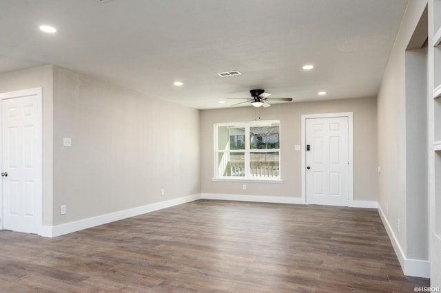 unfurnished room featuring baseboards, visible vents, dark wood-style flooring, and recessed lighting