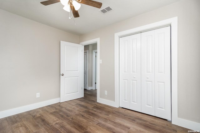 unfurnished bedroom with wood finished floors, visible vents, and baseboards