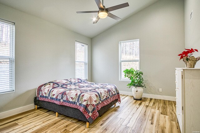 bedroom featuring lofted ceiling, light wood finished floors, visible vents, and baseboards