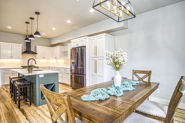 dining space with recessed lighting, light wood-style flooring, and baseboards