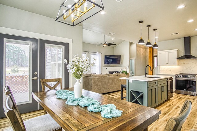 dining space featuring light wood finished floors, lofted ceiling, recessed lighting, visible vents, and ceiling fan