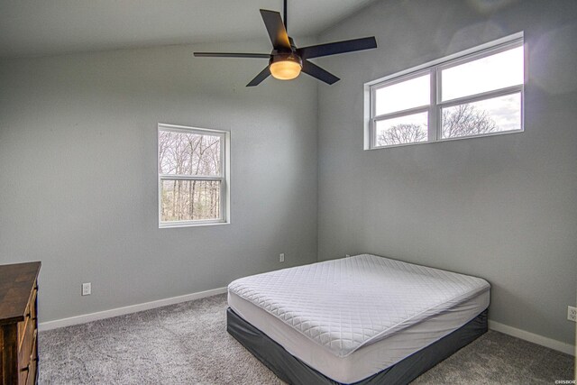 carpeted bedroom featuring a ceiling fan, vaulted ceiling, and baseboards