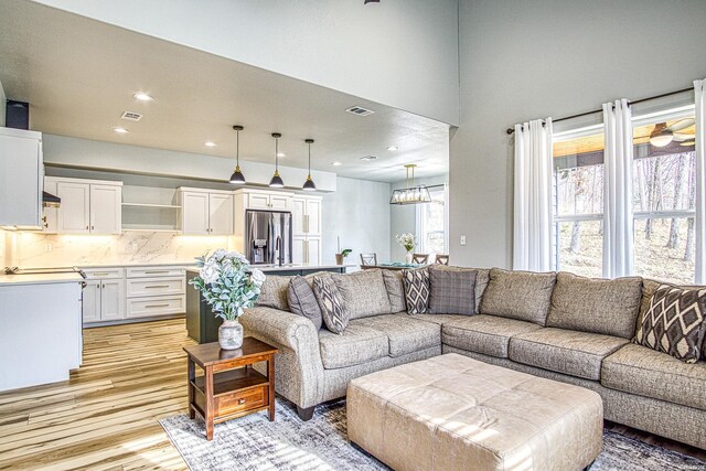 living area with visible vents, light wood-style flooring, and recessed lighting