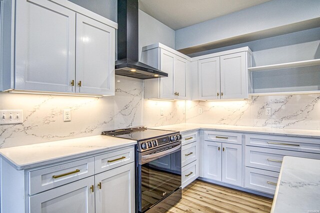 kitchen featuring open shelves, wall chimney range hood, white cabinets, and stainless steel range with electric cooktop