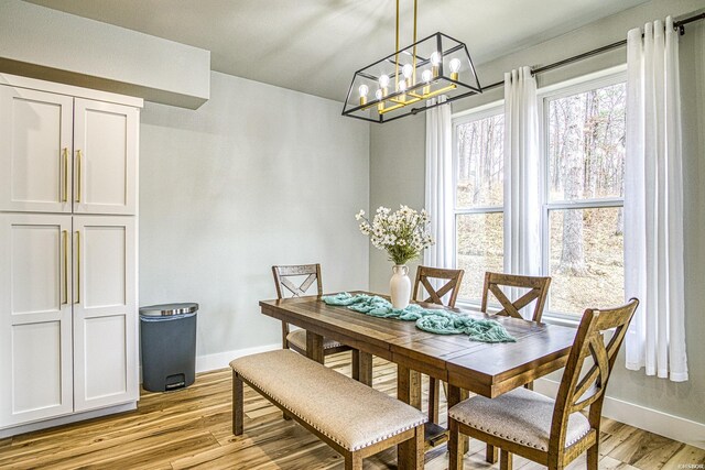 dining area featuring light wood-style flooring and baseboards