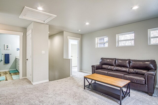 living area with light carpet, baseboards, and recessed lighting