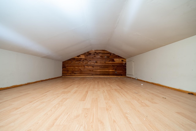 bonus room featuring lofted ceiling, light wood finished floors, and baseboards