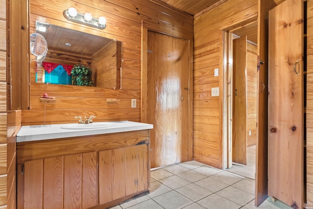 bathroom with wooden walls, wooden ceiling, vanity, and tile patterned floors