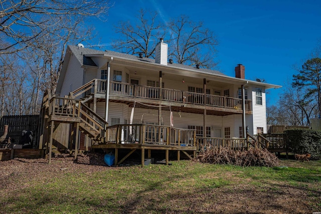 rear view of property featuring a chimney, stairway, and a deck