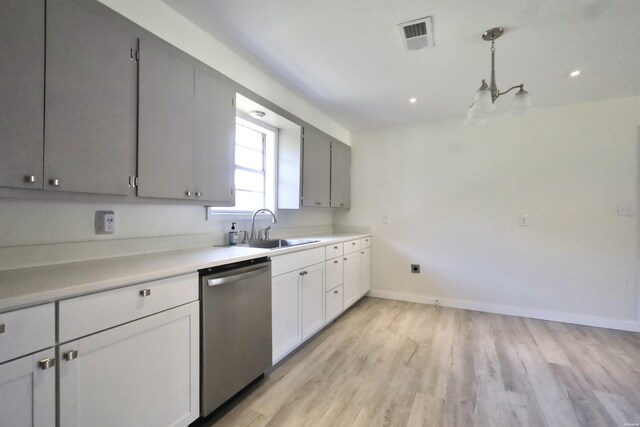 kitchen featuring a sink, visible vents, light countertops, dishwasher, and decorative light fixtures