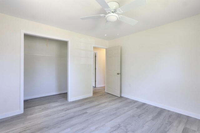 unfurnished bedroom with light wood-type flooring, a ceiling fan, baseboards, and a closet