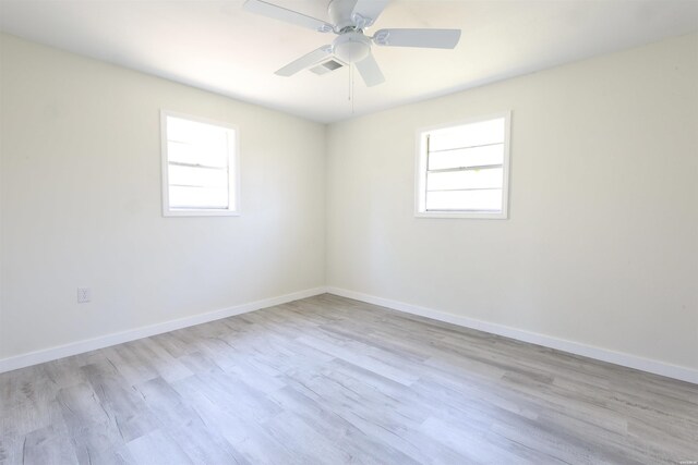 spare room featuring baseboards, visible vents, and a wealth of natural light