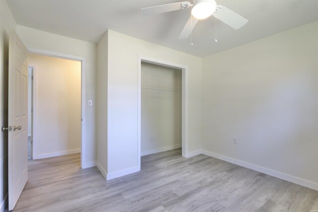 unfurnished bedroom featuring a closet, light wood-type flooring, a ceiling fan, and baseboards