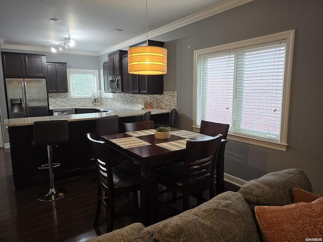 dining area with ornamental molding, dark wood-style flooring, and baseboards