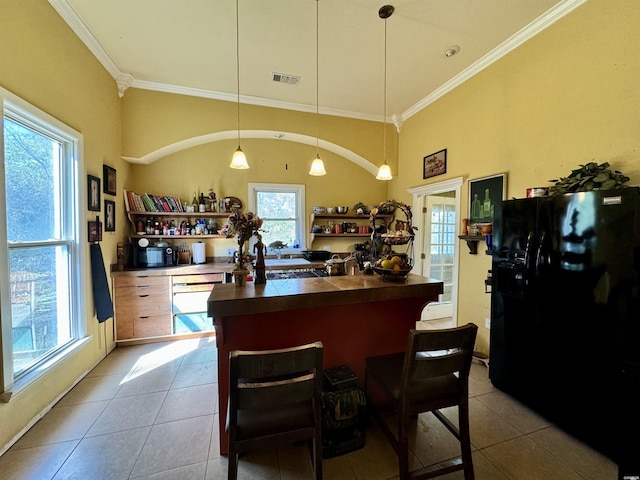 kitchen featuring dark countertops, light tile patterned flooring, black refrigerator with ice dispenser, and hanging light fixtures