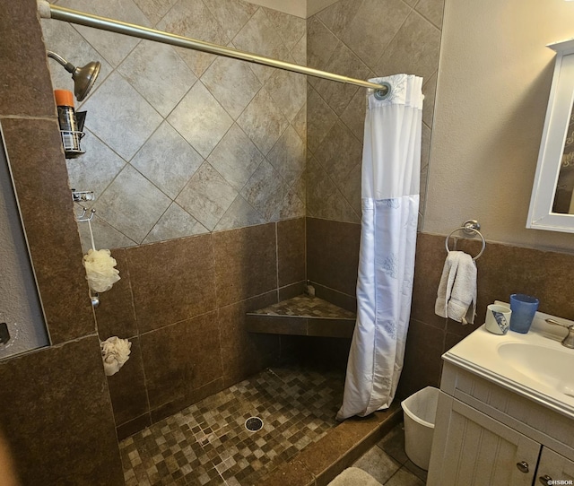 full bathroom featuring wainscoting, a shower stall, and vanity