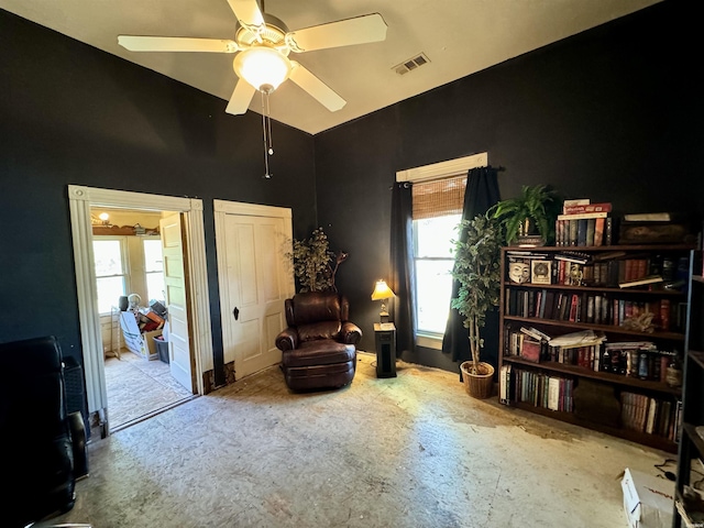 living area with lofted ceiling, ceiling fan, and visible vents