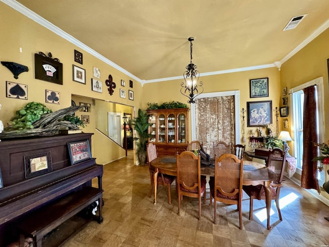 dining area featuring crown molding, visible vents, and a notable chandelier