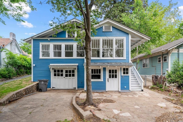 view of front facade with stairway, an attached garage, and concrete driveway