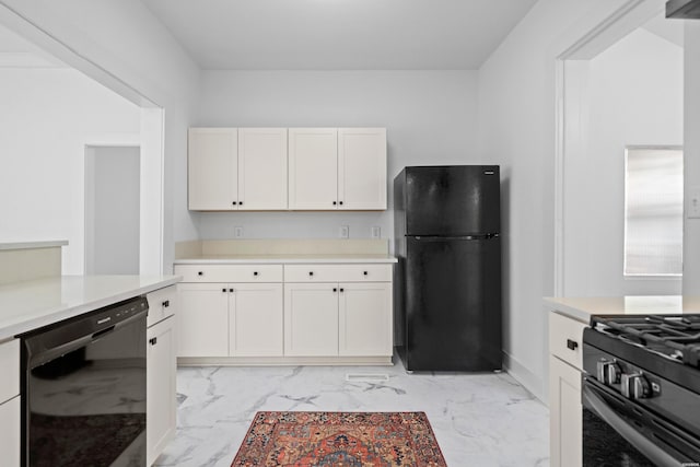 kitchen featuring marble finish floor, baseboards, light countertops, white cabinets, and black appliances