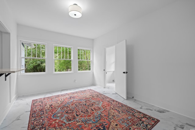 interior space featuring baseboards and marble finish floor