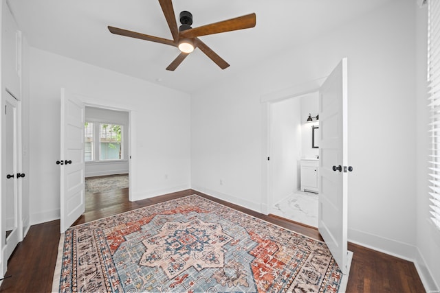 unfurnished bedroom featuring baseboards, ceiling fan, wood finished floors, and ensuite bathroom