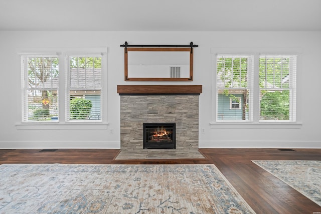 living area with baseboards, a tile fireplace, and visible vents