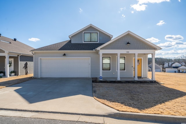 view of front facade with an attached garage, covered porch, a shingled roof, and concrete driveway