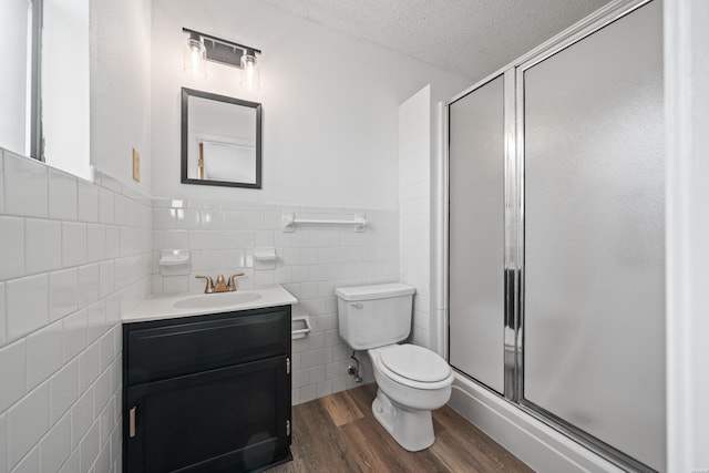 bathroom featuring a shower stall, vanity, a textured ceiling, and wood finished floors