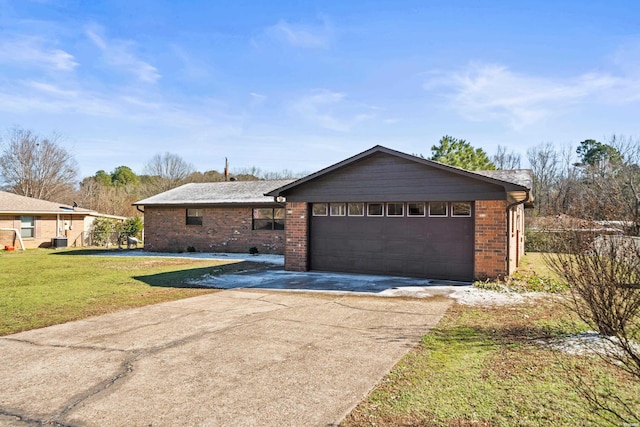 view of front of house with a garage, brick siding, concrete driveway, central AC, and a front yard