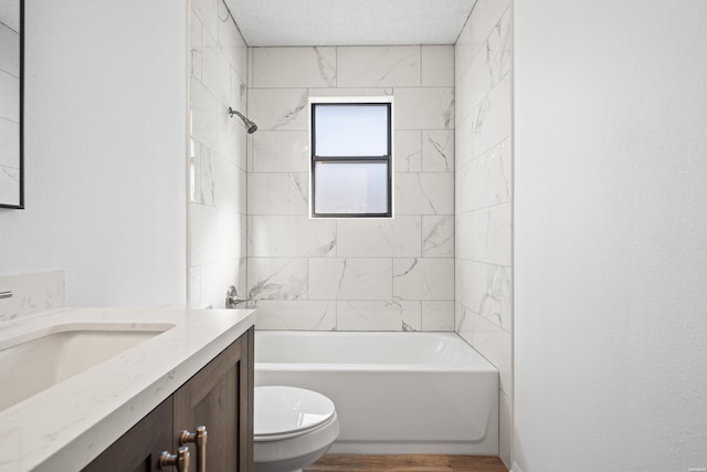 full bathroom with a textured ceiling, bathtub / shower combination, toilet, wood finished floors, and vanity